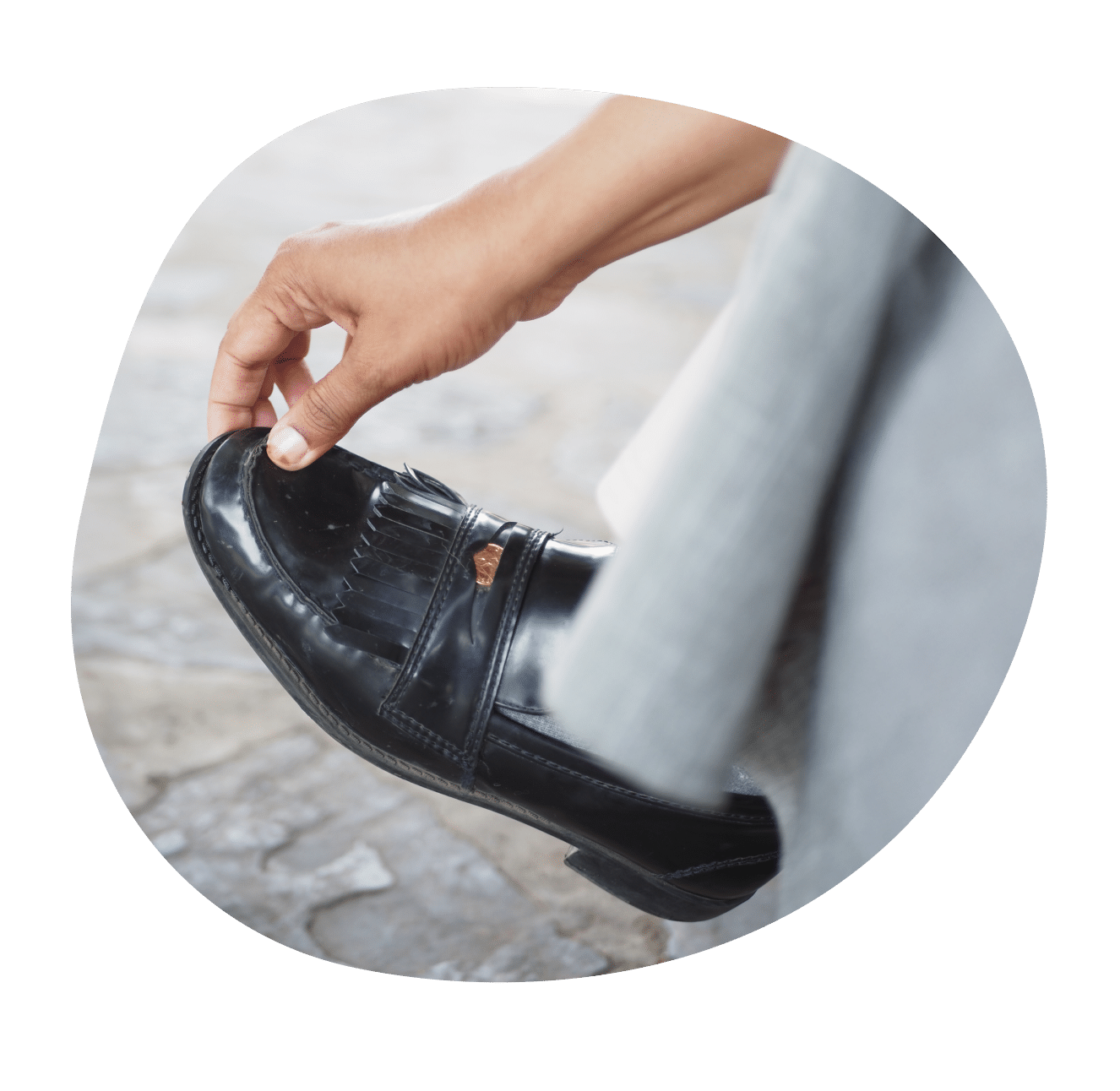 Hand greift nach schwarzem Schuh