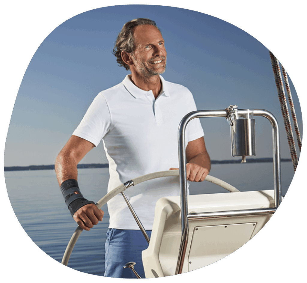 Mann steuert ein Boot auf Wasser mit einer Armbandage